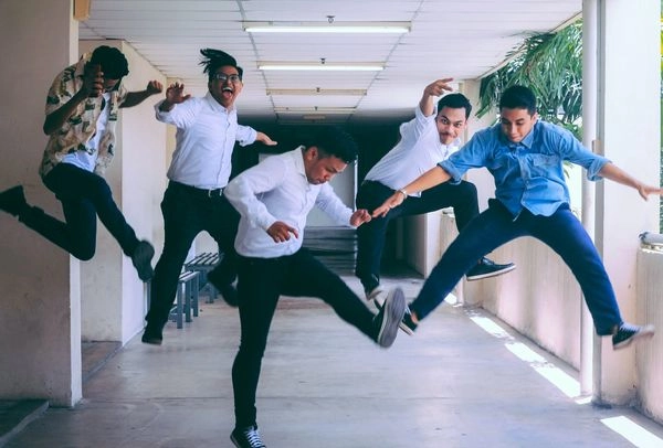 Five employees jumping in the air to illustrate they are having fun in the workplace.