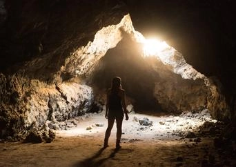 woman standing in sunlight in cave