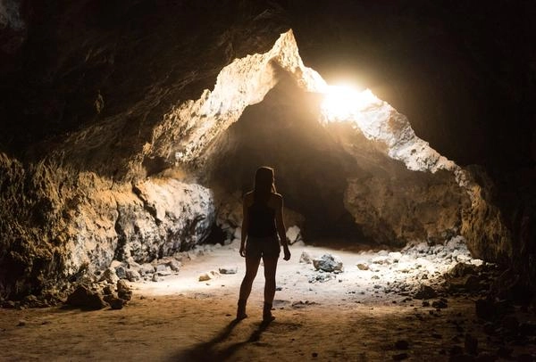 woman standing in sunlight in cave