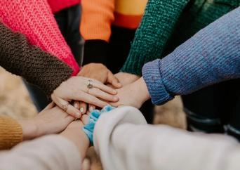 7 hands in a circle showing unity