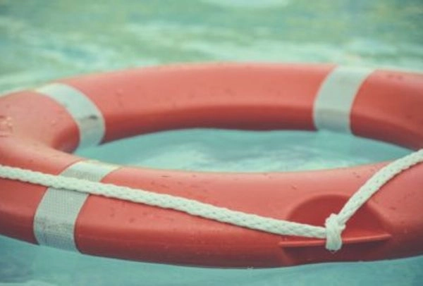Photograph of a life buoy floating in clear water, the life raft Illustrating an Employee Assistance Fund.