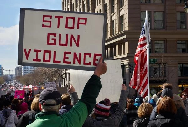 Protesters holding sign saying "stop gun violence"