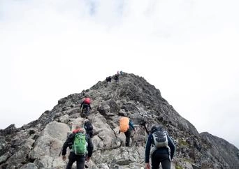 People hiking on a steep mountain