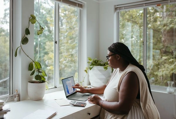 African American woman sitting at home office working on her laptop