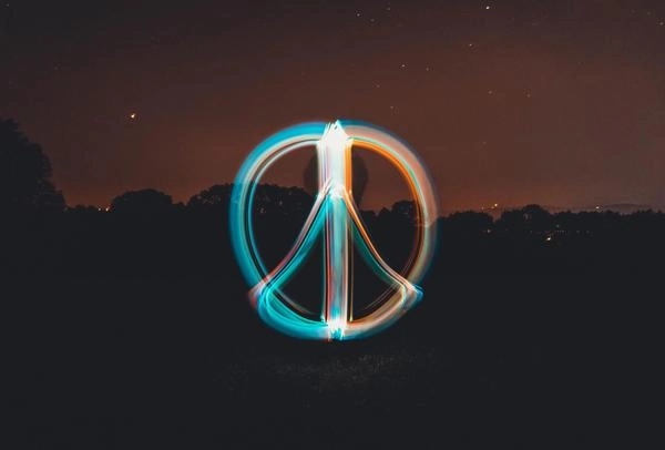 Peace sign in neon lights in a nighttime sky