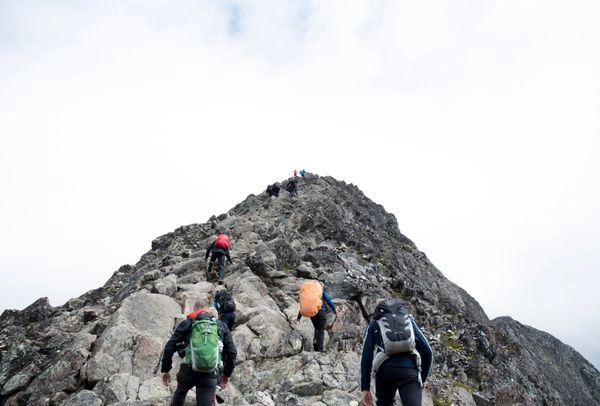 Hikers climbing up a steep mountain