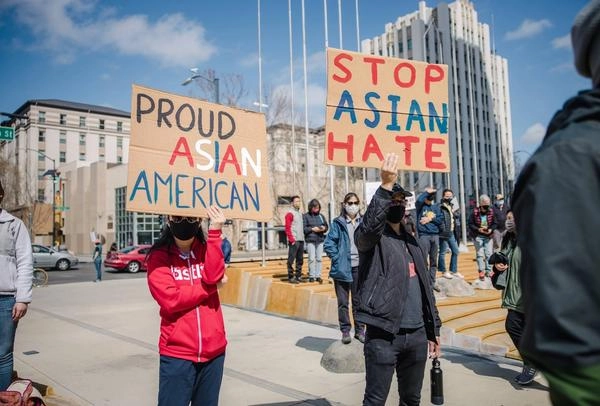 Protestors in the street holding signs saying "Stop Asian Hate"